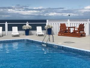 a swimming pool on a balcony with chairs and a table at Motel La Marina in Matane