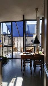 eine Küche mit einem Tisch und Stühlen sowie einem großen Fenster in der Unterkunft Blue Wall BnB in Gebenstorf