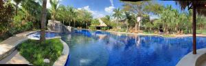 a swimming pool with blue water in a resort at Coco Beach Hotel in Coco