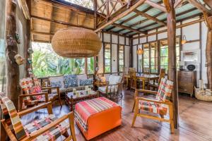 sala de estar con muebles de madera y techo grande en El Ballenato de Bahia, en Uvita