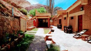 a courtyard of a building with a table and chairs at La Valentina in Purmamarca