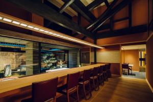 un bar dans un restaurant avec une rangée de chaises dans l'établissement THE HIRAMATSU KYOTO, à Kyoto