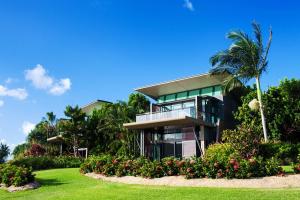 een huis met een palmboom en een tuin bij Yacht Club Villas in Hamilton Island