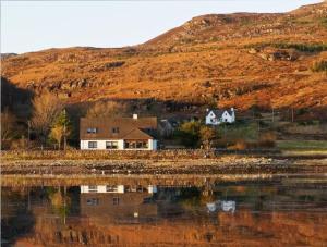 a house on a hill next to a body of water at Ben View in Torridon