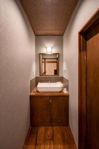 a bathroom with a sink and a mirror at Obama Machiya Stay in Obama
