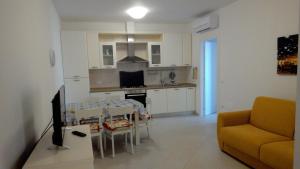 kuchnia i salon ze stołem i kanapą w obiekcie Verde Mare "Appartamenti per Vacanze" w mieście Tortoreto Lido