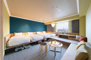 旭川市にあるOMO7旭川 by 星野リゾートの大きなベッドとソファが備わるホテルルームです。