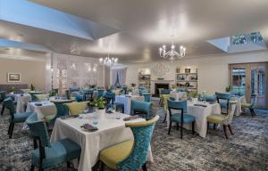 a dining room with white tables and blue chairs at Mount Grace Hotel & Spa in Magaliesburg