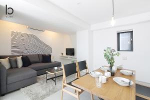 a living room with a table and a couch at bHOTEL Heiwaoodori 1002 - High Rise Apt Famous Hiroshima dori 6ppl in Hiroshima