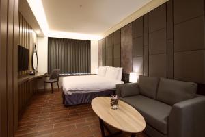 a hotel room with a bed and a couch at Hotel A in Tainan +63 photos