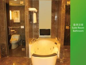 石家荘市にあるHoliday Inn Shijiazhuang Central, an IHG Hotelのバスルーム(バスタブ、トイレ付)、テレビが備わります。