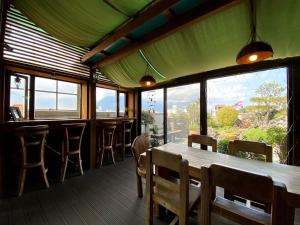 a restaurant with a table and chairs and windows at Ho Feng Private Hotel 電梯自助民宿 in Ji'an