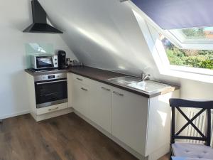 a white kitchen with a sink and a microwave at Ferienwohnung Berger Bocholt in Bocholt