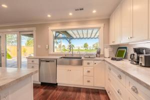 a kitchen with white cabinets and a sink and a window at @ Marbella Lane Executive Waterfront Property in San Mateo