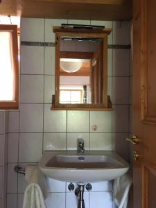 uma casa de banho com um lavatório e um espelho em Pension Christoph em Kramsach