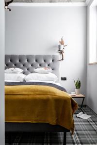 a bedroom with a bed with a yellow blanket on it at Apartamenty Folk & Art Krupówki 25 in Zakopane
