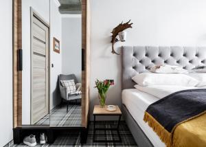 a bedroom with a large bed and a mirror at Apartamenty Folk & Art Krupówki 25 in Zakopane