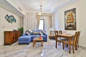 a living room with a blue couch and a table at OYO 490 Home Marbella 2 BR in Dubai