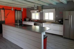 eine Küche mit weißen Schränken und einer großen Arbeitsplatte in der Unterkunft La Maison d'Isabelle in Voissay