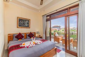 1 dormitorio con 1 cama y balcón en Umah Anila en Ubud