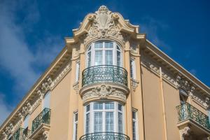 a building with a balcony on top of it at Hotel La Tonkine ex Olympia in Beausoleil