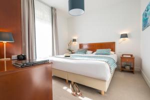 1 dormitorio con 1 cama y escritorio con teclado en Hotel Olympia, en Beausoleil