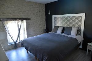 ein Schlafzimmer mit einem großen Bett und einem Fenster in der Unterkunft La Maison d'Isabelle in Voissay