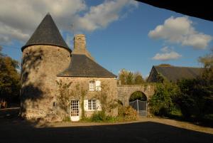 an old stone house with a black roof at Chateau de Flottemanville in Flottemanville