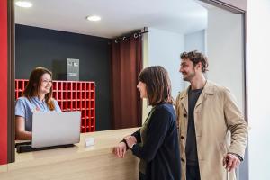 Un groupe de trois personnes debout autour d'un bureau dans l'établissement Aparthotel Adagio Access Avignon, à Avignon