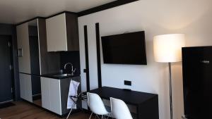 a living room with a black table and white chairs at OY Hotel by WMM Hotels in Oy-Mittelberg