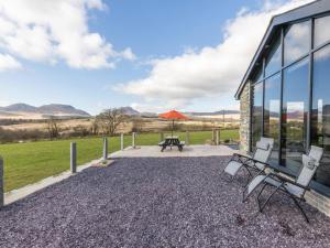 a patio with chairs and a picnic table in front of a building at Cartref in Trawsfynydd