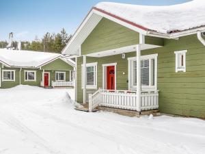SaarenkyläにあるHoliday Home Huoneisto b1 by Interhomeの雪中赤い扉のある緑の家