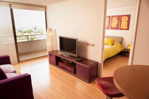 a living room with a flat screen tv on a table at Chilean Suites Providencia in Santiago