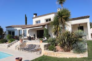 a villa with a swimming pool and a house at La Sousta in La Colle-sur-Loup