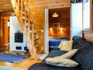 una sala de estar con sofá y una escalera en una cabaña en Holiday Home Meritähti by Interhome, en Kello