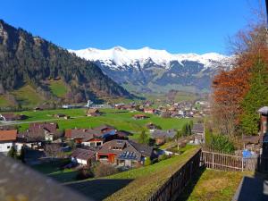 a small village with snow capped mountains in the background at Holiday Home Chalet Guldeli by Interhome in Kandergrund