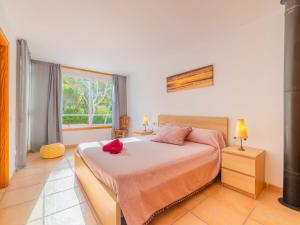 Un dormitorio con una cama con una flor roja. en Holiday Home Golf by Interhome, en Can Picafort
