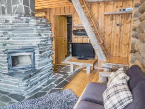 ein Wohnzimmer mit Kamin und Fernseher in der Unterkunft Holiday Home Nousujohde c1 by Interhome in Ruka