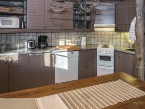 eine Küche mit braunen Schränken und einem weißen Geschirrspüler in der Unterkunft Holiday Home Nousujohde c1 by Interhome in Ruka + 12 Fotos