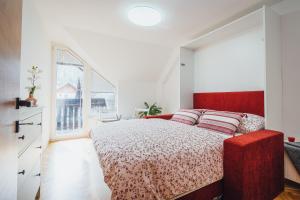 una camera con un letto rosso e una grande finestra di Apartment Via Mons a Kranjska Gora