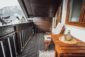 una casa con balcón con mesa y sillas en Apartment Via Mons, en Kranjska Gora