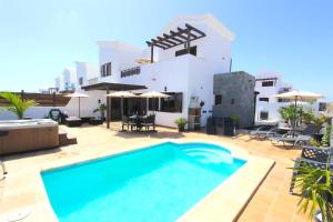 a swimming pool in front of a house at Villa Emma Playa Blanca in Playa Blanca