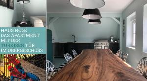 a dining room with a wooden table in a kitchen at Haus Noge Sylt - Offizierhaus Design Appartments strandnah in Westerland (Sylt)