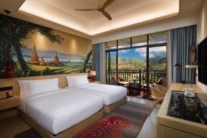 Menghai的住宿－西雙版納悅椿溫泉度假酒店，一间卧室设有两张床和大窗户
