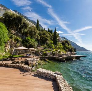 a wooden walkway next to a body of water at Villa Tempesta in Nago-Torbole