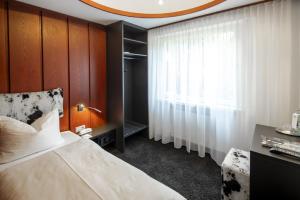 a bedroom with a large bed and a window at Hotel Gloria in Stuttgart