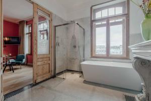 a bathroom with a bath tub and a window at Maison Haas Hustinx & Spa in Maastricht