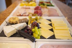 ein Tablett mit Käse und anderen Lebensmitteln auf dem Tisch in der Unterkunft Hotel Gloria Superior in Stuttgart