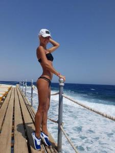 Una donna in bikini in piedi su un molo di Posada del Mirador Italyan Villa a San Bartolo
