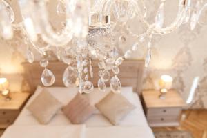 a chandelier with crystals and pillows in a bedroom at Vacation house Artorius in Ljubljana